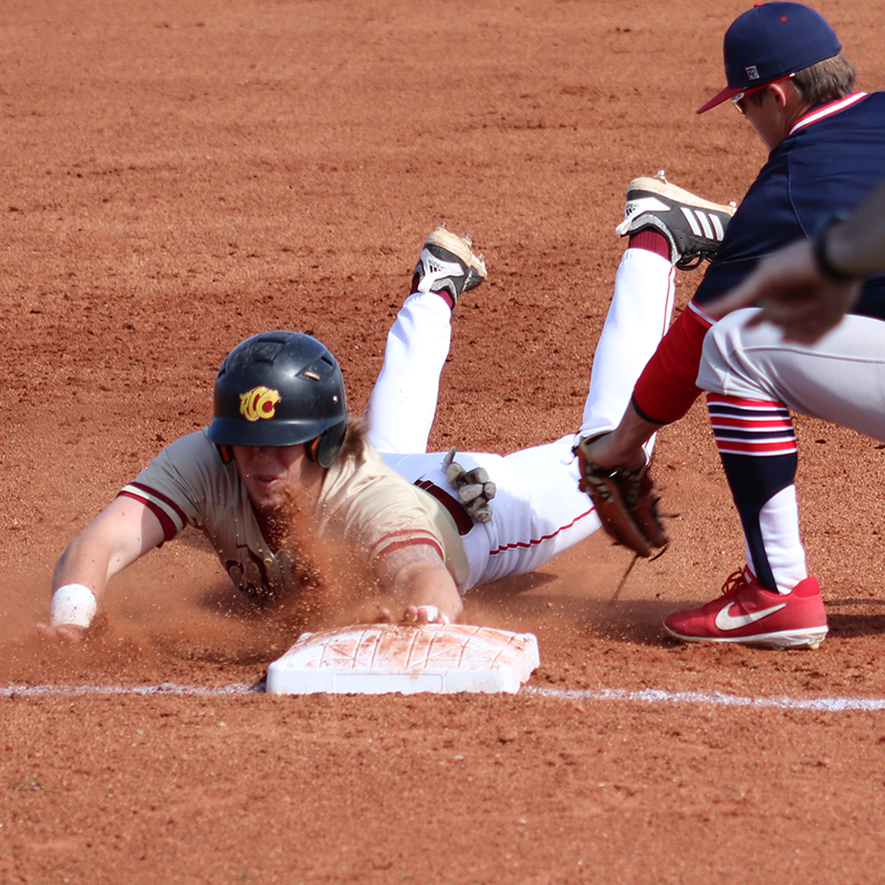 Baseball player sliding into third base
