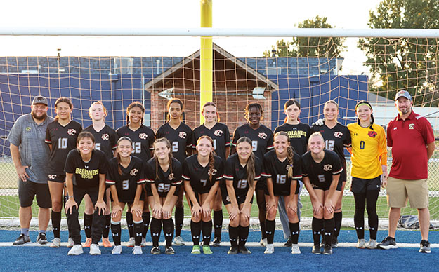 soccer team and coaches standing in front of goal