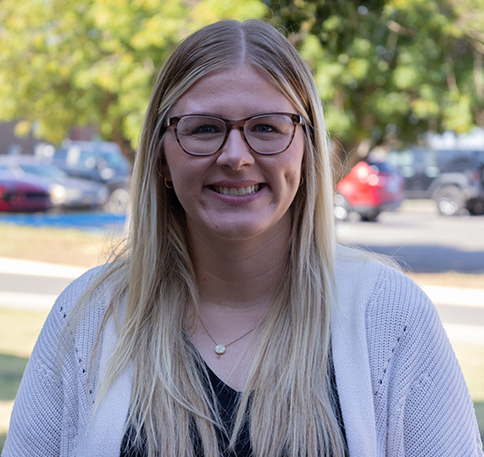 Woman with long blonde hair and glasses