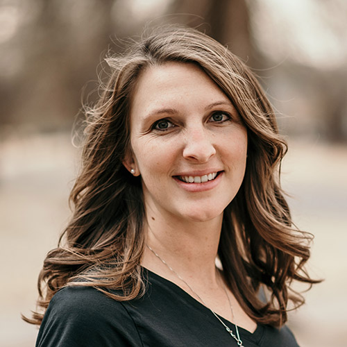 Woman with long brown hair wearing a green shirt