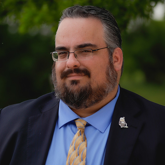 Dark haired man with beard and glasses