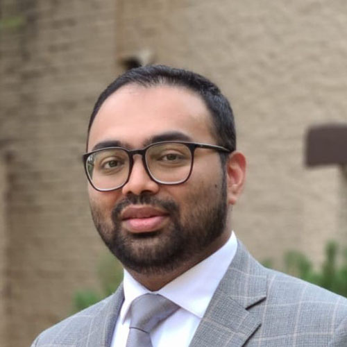 Man with dark hair, beard and glasses