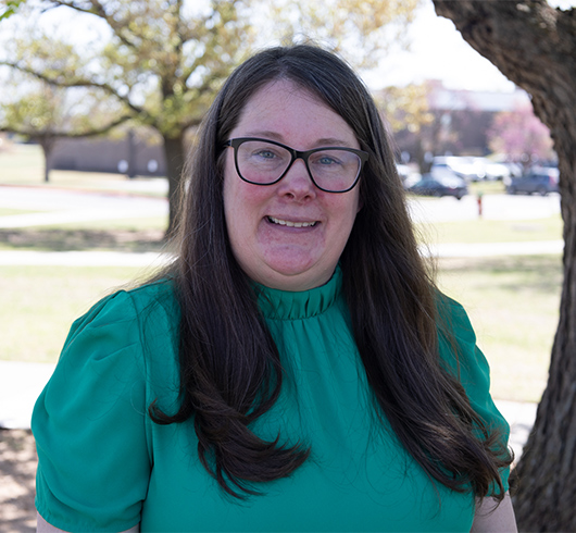 Woman with dark hair and glasses