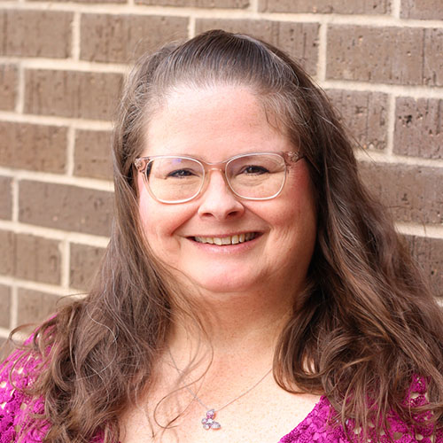 Woman with long brown hair and glasses