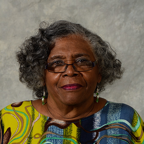 Woman in glasses with a patterned yellow and blue shirt