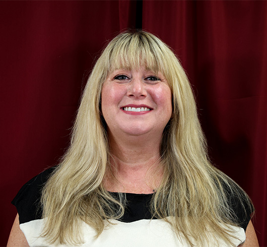 Woman with blond hair and a black and white shirt