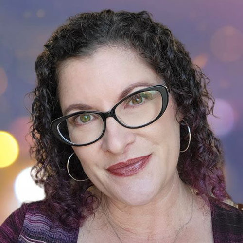 Woman with dark curly hair and glasses