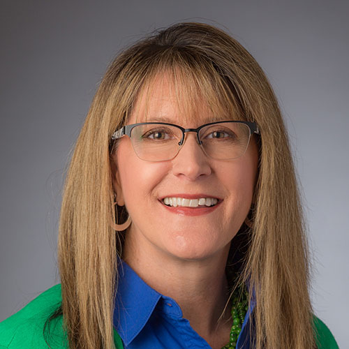 Woman with long brown hair and glasses