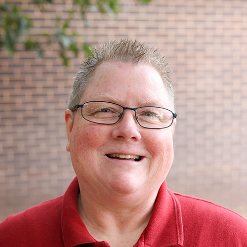 woman with short light hair and glasses