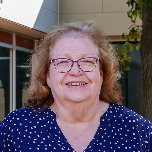 woman with long brown hair and glasses