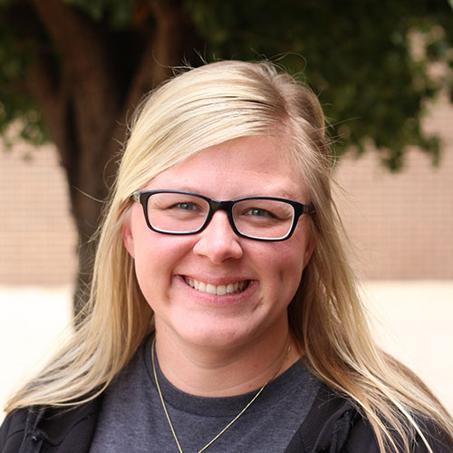 Woman with long blonde hair and glasses