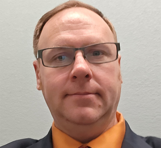 Man with short brown hair and glasses