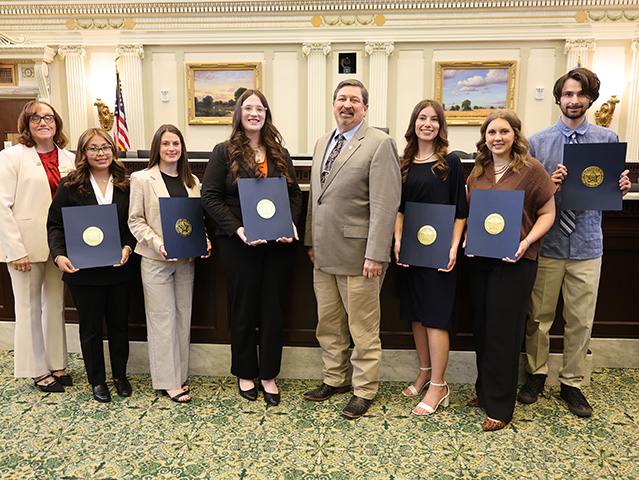 Group of students with president and state representative receiving certificates