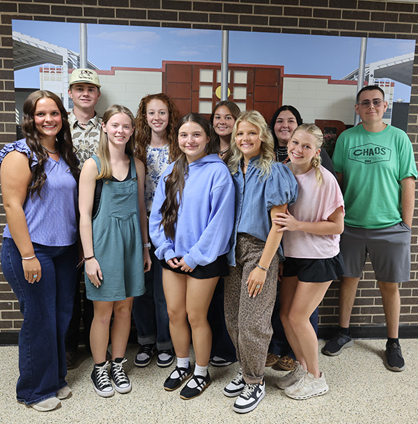 Group of students in front of a picture of campus