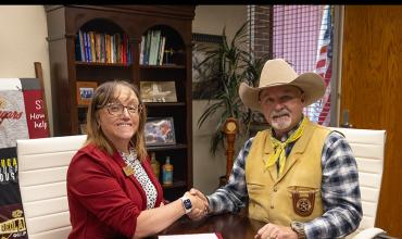 Redlands President Jena Marr and Canadian County Sheriff Chris West shake hands after signing security agreement.